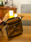 Genuine leather crossbody bag by Atlas Maple featuring a sleek design and adjustable strap, shown in black on a neutral background.