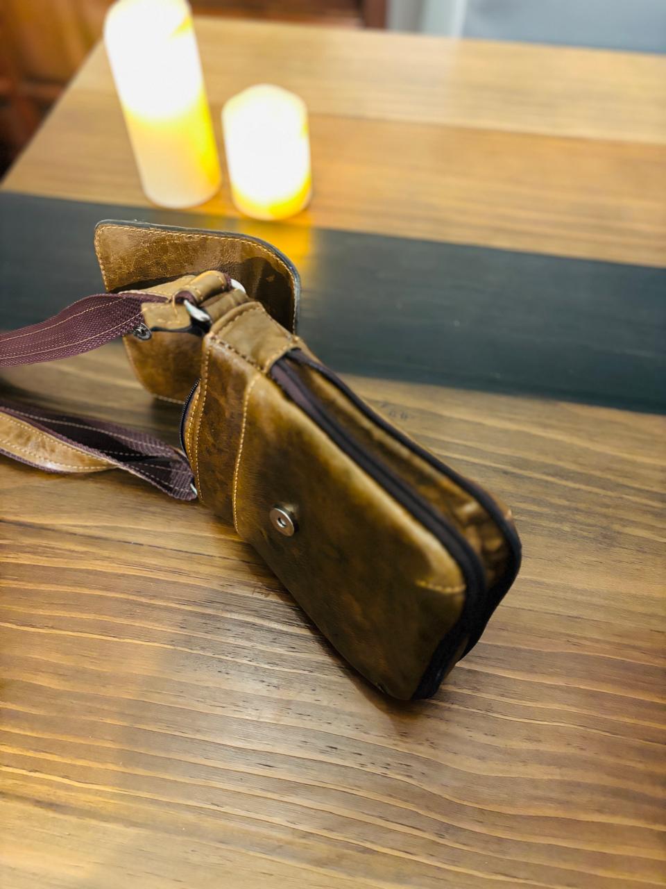 Genuine leather crossbody bag by Atlas Maple with adjustable strap and sleek design, shown in black with visible stitching.